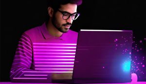 Person coding on laptop with purple glow