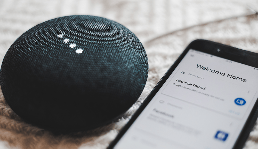 Smart speaker next to smartphone setup screen