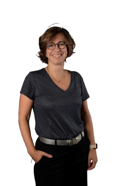 Femme souriante portant des lunettes et une tenue décontractée.