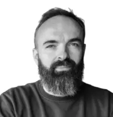 Man with beard and sweater, white background.