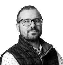 Man with glasses and beard on white background.