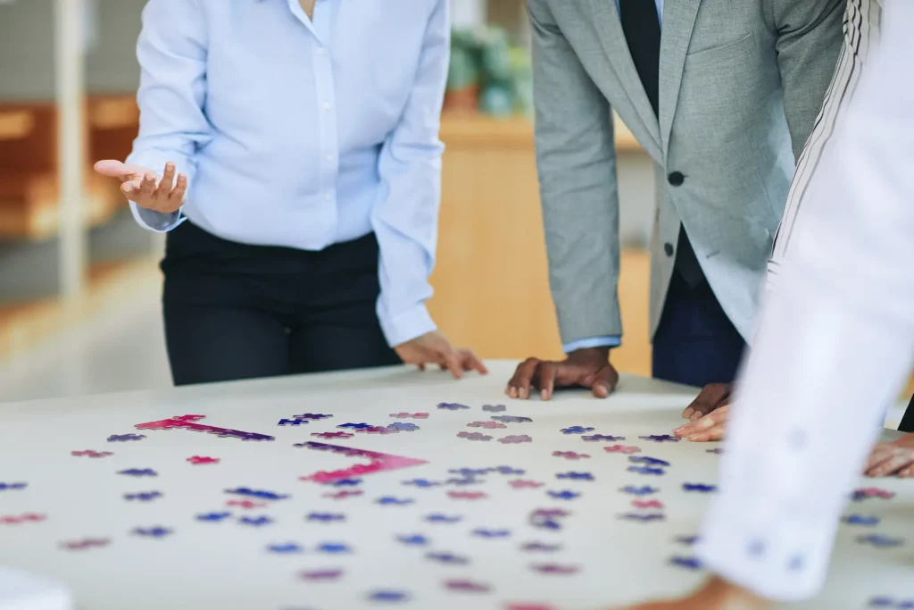 Collègues assemblant puzzle stratégique en réunion
